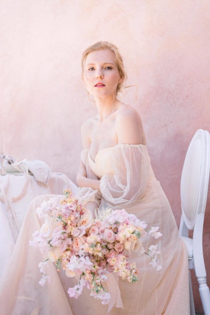 Portrait de mariée assise avec bouquet destructuré